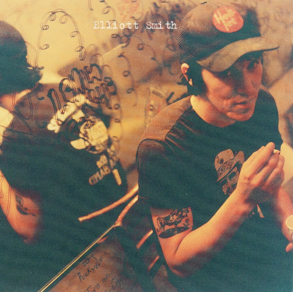 Either/Or by Elliott Smith album cover — Elliott Smith sits backstage with a cigarette in front of a graffiti-covered mirror, photographed by Debbie Pastor during a 1996 show in…